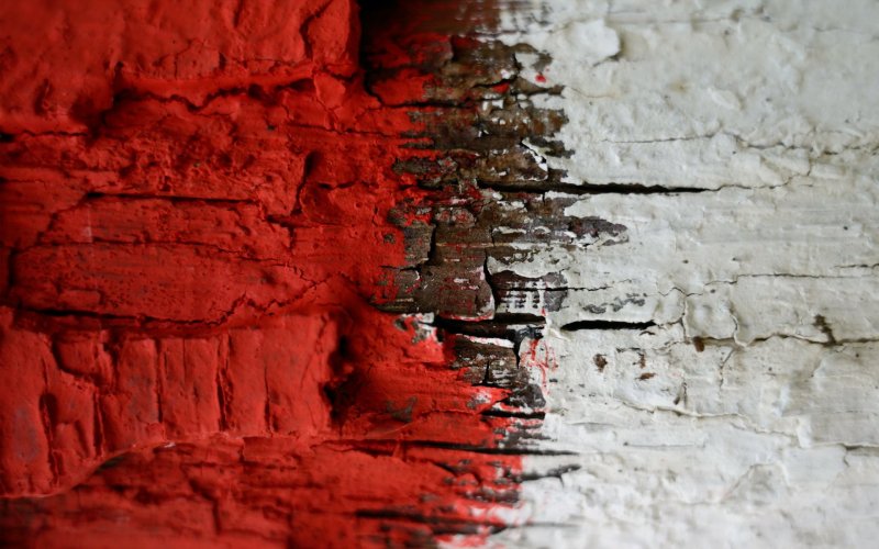 Облупившаяся красная краска на стене