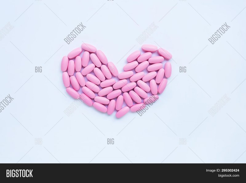 Розовая таблетка на белом фоне