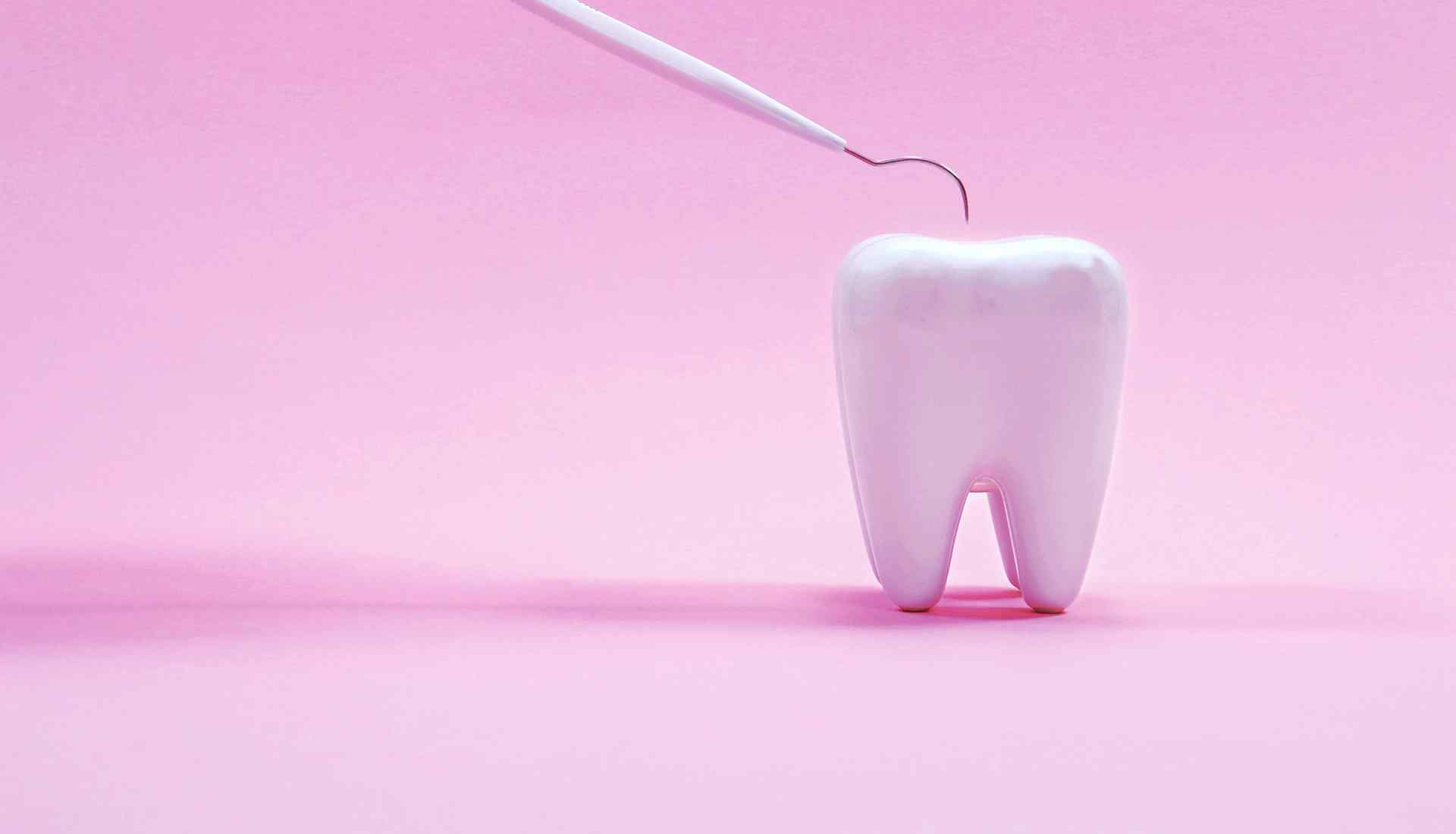 Зуб на розовом фоне