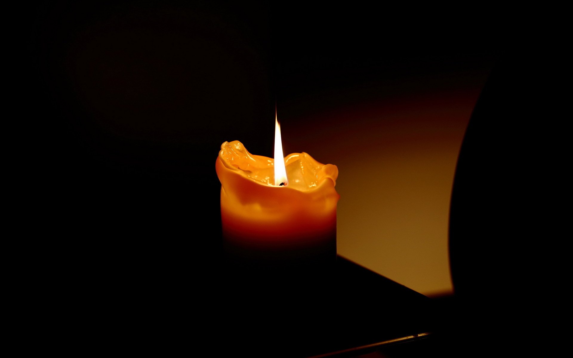 горящая свеча на черном фоне фото