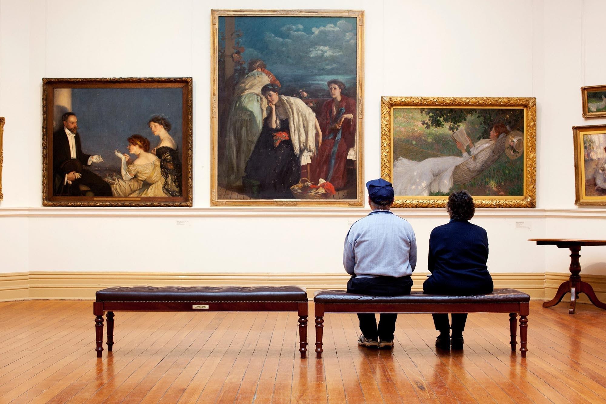 Люди смотрят на картину в музее